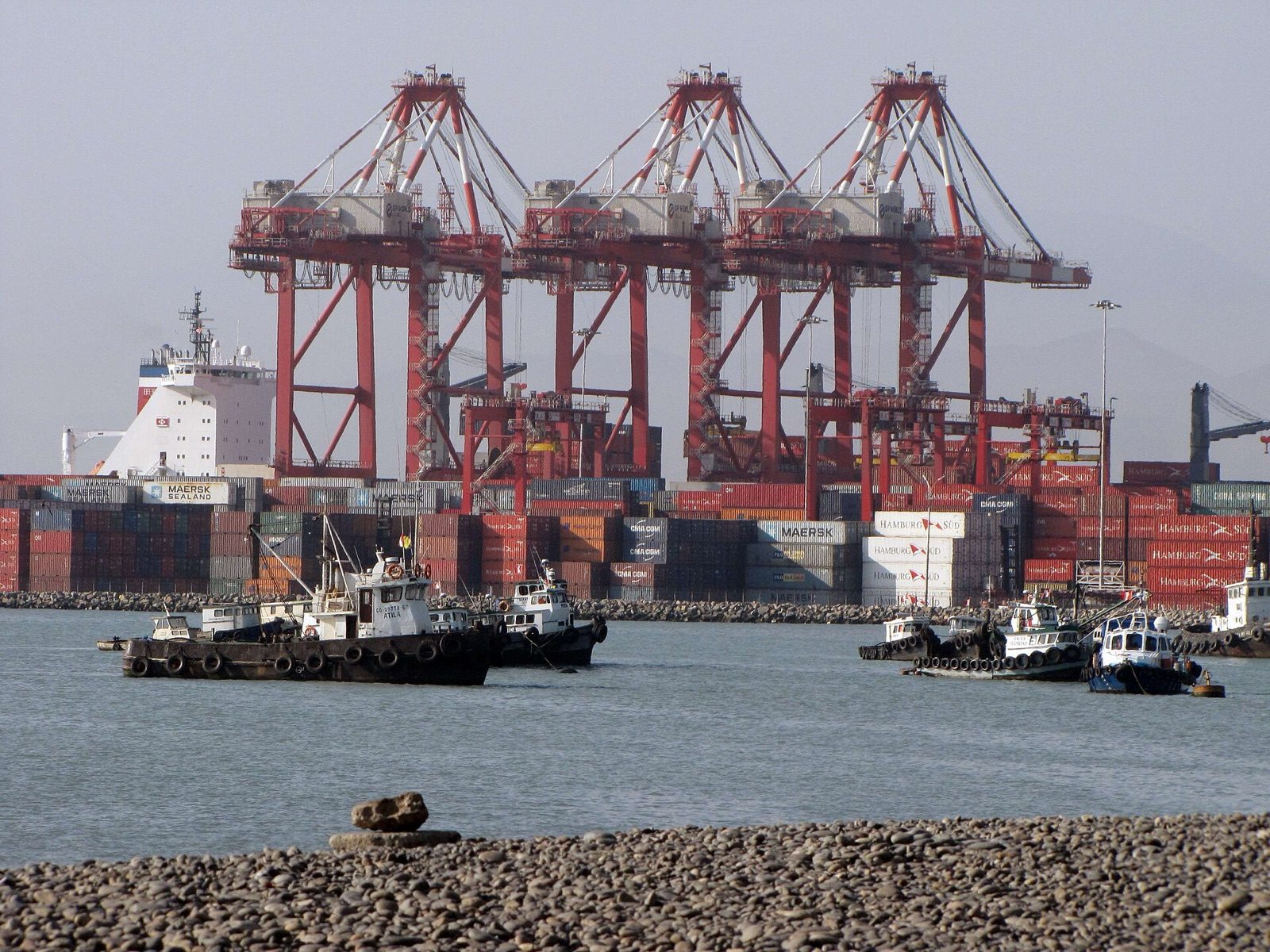 Grúas pórtico y remolcadores en la terminal de contenedores del puerto del Callao, Perú
